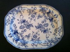 a blue and white plate with floral designs on the rim is sitting on a black surface