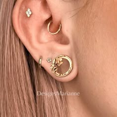 a woman wearing three different types of ear piercings