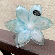 a glass flower sitting on top of a wooden table