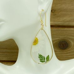 Original real flower earrings made real daisy and leaf, encased in resin in the teardrop gold plated. A truly special and beautiful way to bring nature with you wherever you go! The earrings are LIGHTWEIGHT! Dainty gift for her. When buying my jewelry you may be sure it is original and truly one of a kind ♥ I T E M ~ D E T A I L S: * Lenght: 2.7 inch * Wide: 1.2 inch * Drop length: 1.9 inch * Materials: UV resin, real pressed flower, gold filled wire, gold plated, nickel free. ♥ GIFT IT Jewelry White Teardrop Jewelry With Flower Charm, White Teardrop Flower Earrings, White Teardrop Earrings, White Teardrop Hypoallergenic Flower Earrings, White Pressed Flowers Earrings, White Earrings With Pressed Flowers, Gold Teardrop Flower Earrings With Pressed Flowers, White Teardrop Nature-inspired Jewelry, Gold Birth Flower Jewelry For Summer