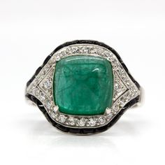 The Trinity ring is a handmade piece inspired by the Art Deco style that centers one natural sugarloaf cut emerald that weighs 3.80ctw. The center stone is surrounded by 30 old mine cut diamonds of H color and VS1 clarity that weigh 0.40ctw and 24 calibrated cut onyxes. Ring measurement: 18mm by 15mm by 9mm Ring size: 7 ½  Total weight: 5.9 grams/ 3.8dwt Art Deco Jewelry Rings, 9mm Ring, Doing The Right Thing, Diamond Platinum Ring, Trinity Ring, Platinum Diamond Rings, The Trinity, Platinum Ring, Art Deco Inspired