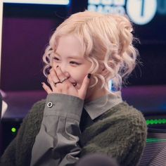 a young woman sitting in front of a computer screen with her hands on her face