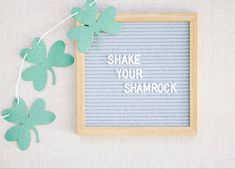 some shamrocks are hanging from a string with the words shake your shamrock on it