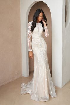 a woman in a white wedding dress posing for the camera