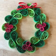 an origami wreath made out of green and pink paper