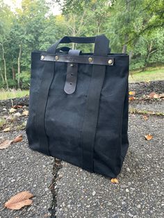 Black waxed canvas tote bag (12.5" x 14" x 7") Polyester straps (1.5") Leather bottom and supports for handle straps. Black Rectangular Satchel With Canvas Lining, Practical Black Bags With Canvas Lining, Black Rectangular Canvas Bag With Canvas Lining, Practical Black Bag With Canvas Lining, Canvas Bags With Top Carry Handle For Outdoor, Black Canvas Satchel With Canvas Lining, Outdoor Canvas Bag With Top Carry Handle, Everyday Waxed Canvas Satchel With Top Handle, Black Coated Canvas Bag With Large Capacity