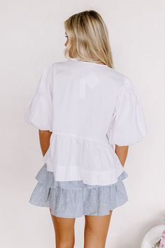 - This chic top is perfect for when you are feeling a bit flirty! - Unlined material - A crew cut neckline - Loose ¾ length sleeves with elastic cuffs - 3 ties at the front ending above the ruffled hemline - A relaxed silhouette that ends in a peplum hemline White Ruffled Puff Sleeve Top For Daywear, Crew Cut, Crew Cuts, Chic Top, Front Tie Top, Tie Top, Sleeve Length, Elastic, Luxury Fashion