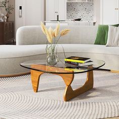 a living room with a couch, coffee table and books on the floor in front of it