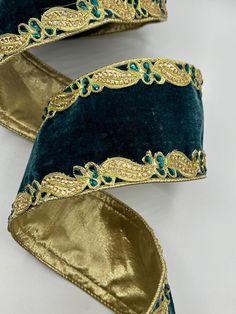 a pair of blue velvet shoes with gold trim