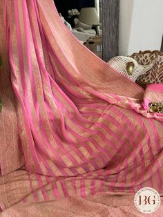 Indulge in luxury and elegance with our Banarasi Khaddi georgette saree in beautiful pink stripes. Handcrafted with intricate details, this saree exudes exclusivity and sophistication. Perfect for any occasion, this saree elevates your style and adds a touch of glamour to your wardrobe. Saree comes with a blouse piece. Fall and pico done. Fully stitched blouse shown in pictures is optional and can be purchased seperately from our blouses and croptops section. For saree video please connect with us on whatsapp @469-937-0606 Ready to be shipped in USA from San Diego, California. All pictures are original pictures. Colors may slightly vary due to pic resolution. Elegant Pink Chanderi Pre-draped Saree, Festive Georgette Pre-draped Saree With Border, Traditional Pre-draped Georgette Saree With Border, Elegant Pink Georgette Blouse Piece, Wedding Pre-draped Georgette Saree With Border, Pink Banarasi Silk Blouse With Sheer Dupatta, Pink Georgette Traditional Wear With Cutdana, Pink Blouse Piece With Border In Traditional Drape Shape, Semi-stitched Pink Blouse Piece With Border