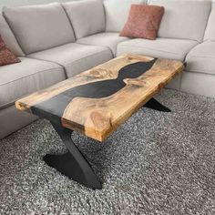 a wooden table sitting on top of a carpeted floor next to a white couch