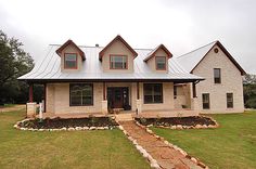 a house with a metal roof in the middle of a field