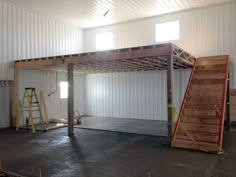 an empty garage with stairs and ladders