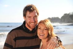 a man and woman standing next to each other on the beach