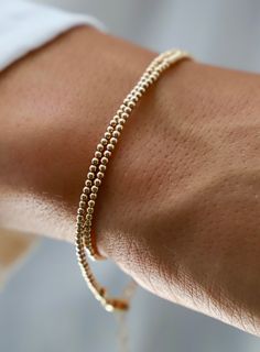 Our double wrap bracelet is one of our number one best selling bracelets! The petite double wrap beaded bracelet is made up of 2mm beads and can be worn as a bracelet or a single layer choker necklace! Also available in Silver. Details: - Gold filled 2mm beads - Gold filled lobster clasp and end chain - 13" with 2" extender SKU: B1116 Materials + Care Gold Wrap Bracelet With Tiny Beads As A Gift, Gold Wrap Bracelet For Layering, Adjustable Gold Minimalist Wrap Bracelet, Gold Adjustable Double Strand Beaded Bracelets, Gold Wrap Bracelet With Spacer Beads As Gift, Gold Stackable Wrap Bracelet For Stacking, Gold Bracelets With Round Beads For Layering, Adjustable Gold Bracelet For Layering, Gold Jewelry With Tiny Beads For Layering