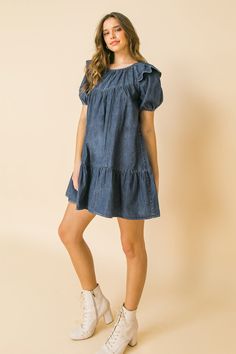 A lightweight denim mini dress featuring round neckline, ruffle at shoulder, puff sleeve, ruffled hemline and keyhole button closure Details Self: 100% Cotton Size & Fit - Model is 5`8" And Wearing Size Small - Measurements Taken From Size Small - Approx. Length: 30.5" Light Wash Knee-length Denim Mini Dress, Medium Wash Knee-length Denim Mini Dress, Mini Length Denim Dress For Day Out, Dark Wash Cotton Denim Mini Dress, Dark Wash Cotton Mini Denim Dress, Dark Wash Mini Denim Dress, Medium Wash Denim Mini Dress, Washed Denim Mini Dress, Medium Wash Mini Denim Dress