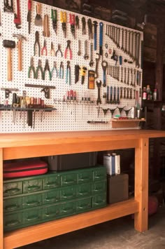 the workbench is full of tools, including hammers and wrenches on the wall