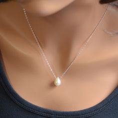 "You can't go wrong with the classic pearl drop necklace. This simple teardrop design will go with everything and is pretty enough for special occasions as well. A creamy white, genuine teardrop pearl slides freely along sterling silver chain in this floating pearl necklace. This lovely pearl is a full drop shape and measures approx. 13mm tall x 9mm wide. Tiny white pearls connect the sterling silver lobster clasp. Simply elegant, and perfect for the bride who wants a minimalist, classic piece o Pearl White Teardrop Pearl Necklace As A Gift, Pearl Teardrop Drop Necklace With Pearl Charm, Pearl White Teardrop Pearl Necklace For Gifts, Teardrop Pearl White Pearl Necklace For Gift, Teardrop Pearl White Necklace As A Gift, Elegant Teardrop Drop Necklace With Pearl Charm, Dainty Teardrop Pearl Charm Necklace, Gift Teardrop Pearl White Necklace, Pear-shaped Drop Necklace With Pearl Chain For Gift