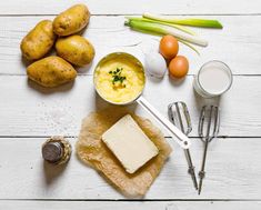 potatoes, eggs, butter and other ingredients on a white wooden table