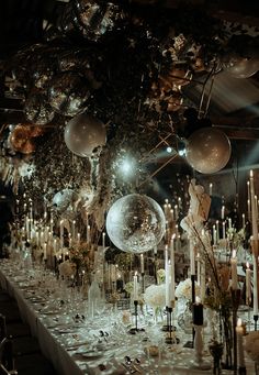 a long table with many candles and decorations on it, all set up for a party