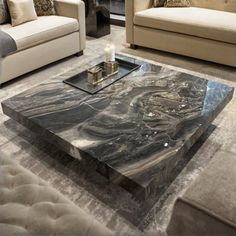 a living room with couches, chairs and a marble coffee table in the middle