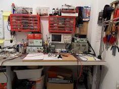 a workbench with lots of wires and tools on it's desk area