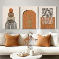 three abstract paintings hang on the wall above a white couch in a modern living room