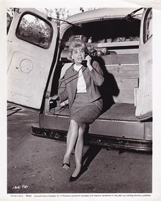 an old black and white photo of a woman sitting in the back of a van