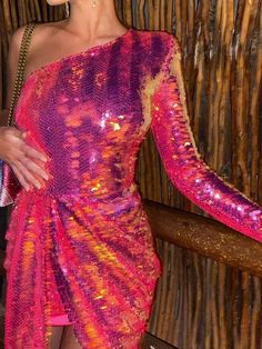 a woman in a pink and orange dress posing for the camera