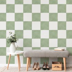 a bench sitting next to a wall with green and white checkered tiles on it