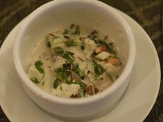 a white bowl filled with food on top of a plate