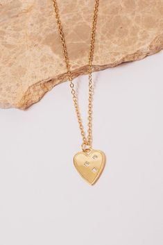 closeup of clasp and Janna Conner tag on cable chain Gold Heart Necklace With Tarnish Resistant Round Pendant, Gold-tone Heart Pendant Necklace With Tarnish Resistance, Gold Heart Necklace With Round Pendant, Tarnish Resistant, Gold-tone Heart Pendant Necklace Tarnish Resistant, Gold-tone Tarnish Resistant Heart Pendant Necklace, Gold-tone Tarnish-resistant Heart Pendant Necklace, Gold Plated Heart Pendant Necklace Tarnish Resistant, Gold-tone Tarnish Resistant Necklace For Valentine's Day, Valentine's Day Gold-tone Tarnish Resistant Necklace