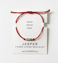 a red string bracelet with a silver bead on it and the words jasperr written