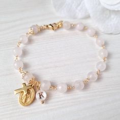 This dainty Rosary bracelet in natural Rose quartz ( faceted) is a beautiful way to carry your faith with you every day. The elegant beads are complemented with unique letters in natural mother of pearls, handmade by me too. Handcrafted with care and attention to detail, this bracelet is not only a stunning accessory but also a meaningful symbol of your spiritual journey. Whether it's a gift for yourself or a loved one, this rosary bracelet is a unique and thoughtful piece that will be treasured Affordable Pink Rosary Bracelet For Gift, Faceted Beads Rosary Bracelet For Gift, Spiritual Rose Gold Rosary Bracelet Gift, Rose Quartz Beaded Bracelet With Faceted Beads As Gift, Spiritual Rosary Bracelet With Faceted Beads As Gift, Adjustable Spiritual Rosary Bracelet For Mother's Day, First Communion Gifts, Faith Gifts, Rosary Bracelet