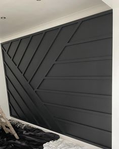 a bed sitting under a black paneled wall