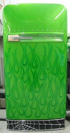 a green refrigerator sitting on top of a floor next to other items in a room