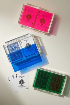 three different colored playing cards on a table