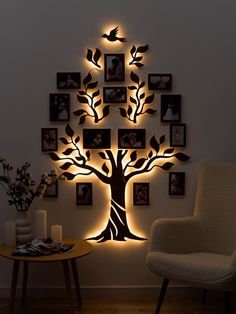 a tree with many pictures on it is lit up by the light of a lamp