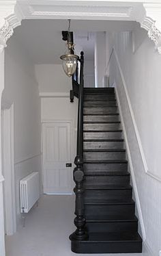 a black and white staircase leading up to a light on top of a lamp post