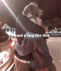 two people hugging each other in front of a car with the words i want a hug like this