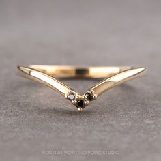 a gold ring with black stones on it