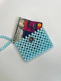 a blue beaded purse with a credit card holder attached to the front and side