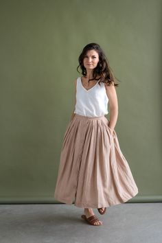 Feminine meets practical - this wonderfully woven sweet button-down skirt is flattering, has a softly gathered waist, deep pockets, and pairs well with any kind of fashion sense. Functional buttons descending down the front, create the perfect summer day look. Carefully gathered folds both in front and back create a beautiful A-line shape. It is made of natural linen, which makes you feel comfortable, free in movements and also very special. It fastens with front buttons and sits best when high Daywear Skirted Bottoms With Pockets, Skirted Bottoms With Pockets For Day Out, Beige Buttoned Long Skirt, Casual Voluminous Skirt Bottoms For Daywear, Long Skirt With Pockets For Daywear, Casual Voluminous Skirt For Daywear, Beige Long Skirt With Buttons, Button-up Beige Skirt For Summer, Spring Flared Skirt With Button Closure