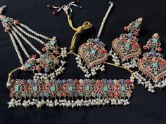 The jewelry set being offered here is a traditional Noratan bridal set, often worn during weddings or other formal occasions in Indian and Pakistani cultures. It is a multicolor set that can complement with many outfits and can be worn at many formal occasions. Here's a detailed description of this Navratan set  - **Noratan Bridal Choker The choker is  grand and intricate, typical of Noratan designs. It  features a combination different color embedded beads on a golden background.  The design is Navratan Set, Pakistani Culture, Golden Background, Bridal Choker, Many Outfits, Choker Set, Staten Island, Bridal Set, Pakistani Fashion