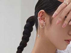 a woman is holding her hands to her face and wearing earring set with pearls