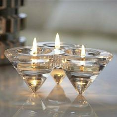 small candles are placed in glass bowls on a table