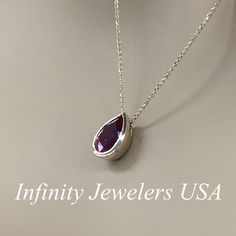 "The pendant pictured is a lab created red ruby #6930 -Approximate total carat weight: approx. 2.00ctw diamond equivalent -Center Stone Size: 10x7mm - approx. 2.00ct diamond equivalent -Center Stone Shape: pear -Gem Type: lab created ruby -Stone Clarity: AAA -Stone Color: Red -Moh's Scale: 9 hardness -Metal Type and Purity: 14k yellow gold -Setting: bezel set -Chain: delicate 14k gold chain / heavier option with lobster claw available (use dropdown to select) -Country of Manufacturing: USA (Mich Ruby Drop Jewelry For Anniversary, Teardrop Ruby White Gold Jewelry, Teardrop Ruby Jewelry In White Gold, Anniversary Ruby Jewelry With Bezel Setting, Formal Ruby Teardrop Pendant Jewelry, Formal Ruby Necklace With Bezel Setting, Pear-shaped Ruby Jewelry For Anniversary, Classic Jewelry With Polished Lab-created Ruby, Pear-shaped Ruby Necklace For Anniversary