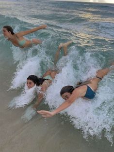 three women are in the water on their surfboards