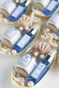 several bottles of sea salt and seashells on small trays