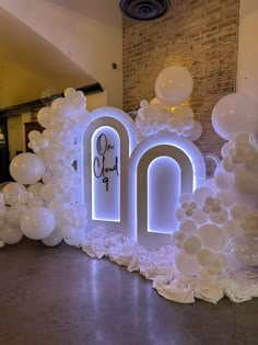 an arch made out of balloons with the letters o and n on it in front of a brick wall